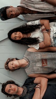 three people standing next to each other in front of a white wall with wood planks