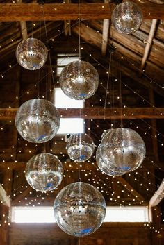 disco balls hanging from the ceiling in a barn