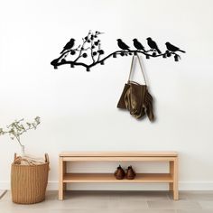 two birds sitting on a tree branch with coat rack and shoes hanging from it's hooks