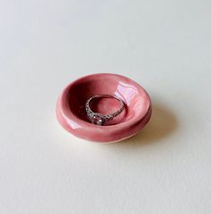 a pink bowl with a wedding ring in it