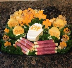 a platter filled with cheese, meats and other foods on top of a table