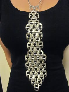 a woman wearing a black shirt with a silver necklace on it's neck,