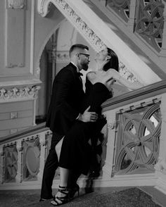 a man and woman standing next to each other on stairs