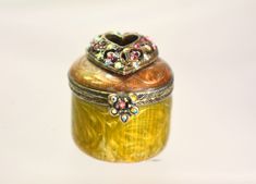 an ornate wooden box with jeweled decorations on it's lid sitting on a white surface