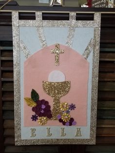 a banner with flowers and a cross hanging from it's side on a table