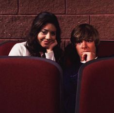 two people sitting in chairs with their hands on their chins and looking at the camera