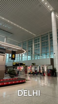 an airport terminal with people waiting for their luggage