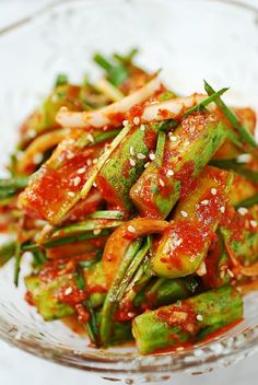 a glass bowl filled with vegetables covered in sauce