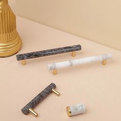 three marble and brass handles on a table