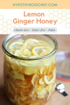 a jar filled with lemon ginger honey sitting on top of a table next to a spoon