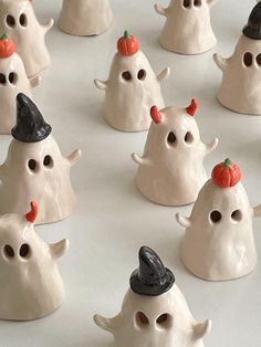 there are many little white ghost figurines with hats on their heads and noses