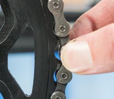 a hand holding a black bicycle chain