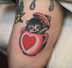 a cat in a cup with a heart tattoo on its arm and leg is shown