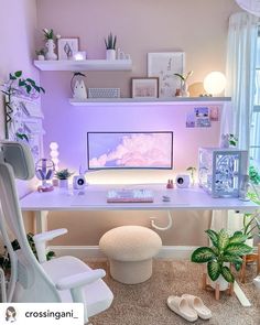 a white desk with a computer on it in a room filled with plants and other items