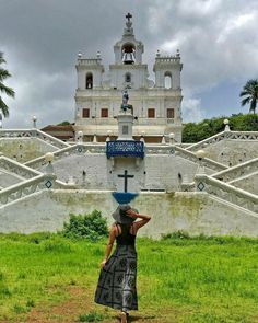 a woman standing in front of a church with a cross on it's head