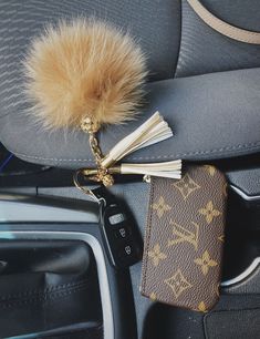 a car keychain with a fur ball hanging from it's center console