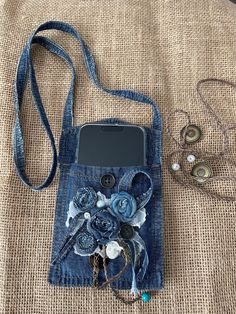 a cell phone case made out of jeans with flowers on the front and back side