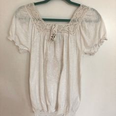 100% Cotton Top With Lace Trim. Elasticized Sleeves And Bottom. Embroidered Pattern In Front. Very Light Cotton Perfect For Staying Cool In The Fire Swamp Summer ! Beige Casual Peasant Top For Daywear, Casual Beige Peasant Top For Daywear, Casual White Blouse With Crochet Trim, Casual Cream Peasant Top, Casual Embroidered Top With Lace Trim For Summer, Casual Beach Peasant Top With Floral Embroidery, Bohemian Short Sleeve Top With Crochet Trim, Casual Summer Peasant Top With Crochet Trim, Casual Short Sleeve Crochet Top With Lace Trim