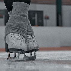 the legs and feet of an ice hockey player on the ice rink in black and white