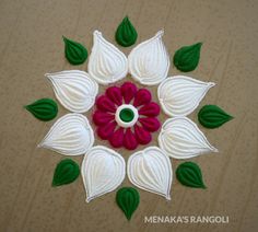 a close up of a flower made out of felt with green leaves and red flowers