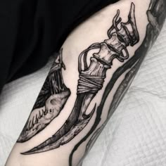 a man's arm with a tattoo on it and a knife in the middle