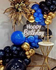 a birthday party with balloons and decorations in blue, black, gold and white colors