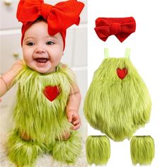 a baby wearing a green furry outfit with red hearts on it's chest and two matching hair clips