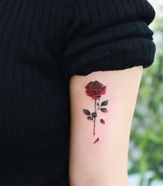 a woman's arm with a rose tattoo on the left side of her arm