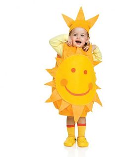 a baby in a yellow costume is smiling and sitting on top of a stuffed animal