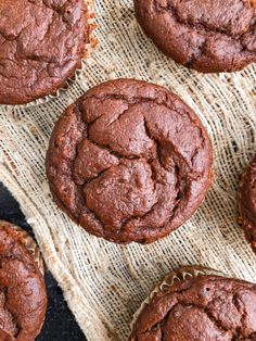 chocolate muffins sitting on top of a cloth