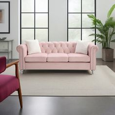 a living room with two chairs and a pink couch