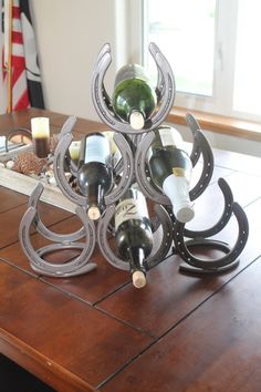 a wooden table topped with bottles of wine next to a candle holder on top of it