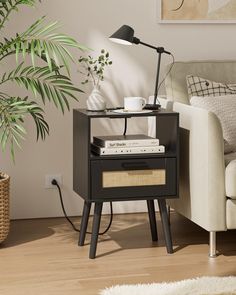 a black end table with a lamp and some books on it next to a couch