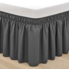 the pleated bed skirt is made from dark gray fabric