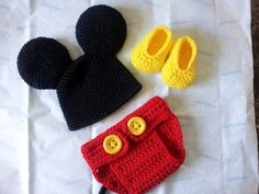 three crocheted items are laid out on a sheet, including a hat and purse