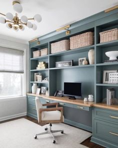 a home office with blue bookcases and white carpet