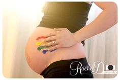 a pregnant woman with her hands painted on her belly