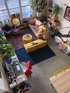 an overhead view of a living room with couches, tables and bookshelves