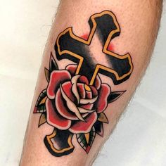 a cross and rose tattoo on the leg