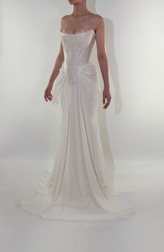 a woman in a white wedding dress standing up against a white background with her hands on her hips