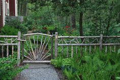 a wooden gate in the middle of a garden