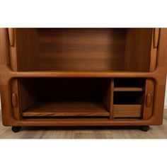 a wooden entertainment center sitting on top of a hard wood floor