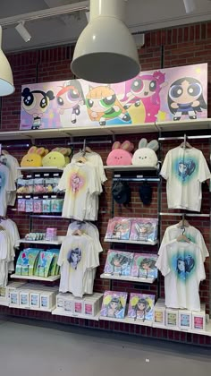 there are many t - shirts on display in the store with pictures and other items