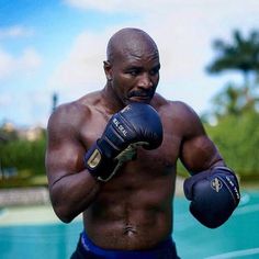 a man wearing boxing gloves standing in front of a swimming pool