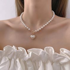 Envuélvase en elegancia con este collar de perlas con forma de corazón. Las perlas brillantes se combinan con un encantador colgante en forma de corazón para crear una pieza atemporal que agrega un brillo romántico a cualquier conjunto. Perfecto para quienes buscan una combinación de gracia clásica y encanto entrañable Heart Pendent, Romantic Necklace, Toggle Necklace, Heart Pendant Gold, Neck Jewellery, Pearl Choker Necklace, Trendy Necklaces, Faux Pearl Necklace, Pearl Choker