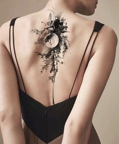 the back of a woman's neck with an artistic tattoo design on her chest