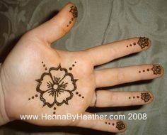 henna tattoo designs on the palm of a woman's hand with flowers and leaves