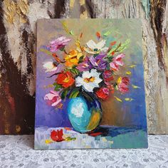 a painting of colorful flowers in a blue vase