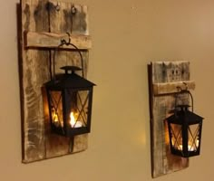 two lanterns are hanging on the wall next to each other, one is lit and the other has a candle in it