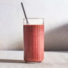 a smoothie in a glass with a straw sticking out of it's side